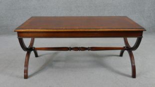 A Regency style mahogany coffee table, the rectangular crossbanded top on curved end supports joined