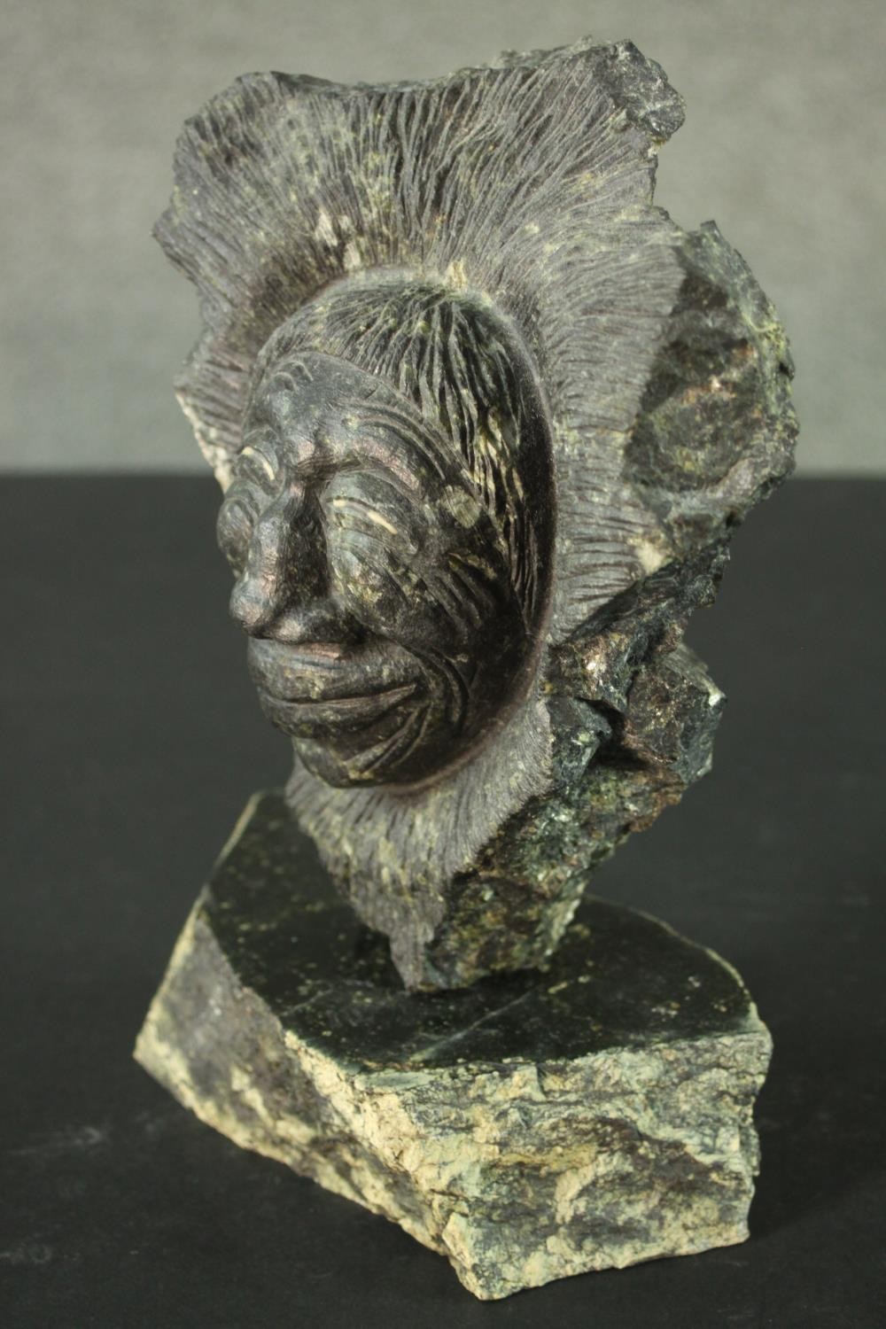Joseph Suqslaq, Inuit, 1958- a carved green hardstone sculpture of a head of a man on a slab base, - Image 7 of 10