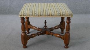 A Victorian walnut stool, upholstered in tapestry style fabric, on turned legs joined by turned X