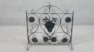 A wrought iron fire screen of rectangular form with scrolling decoration, applied with