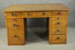 An early to mid 20th century oak pedestal desk, with three short drawers, over two slides, above two