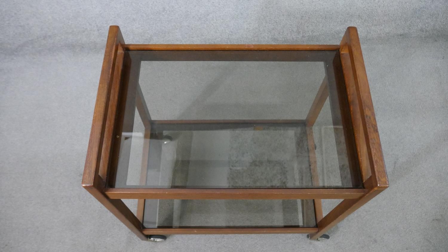 A circa 1960s mahogany drinks trolley, with two tiers of clear plate glass, on castors. H.72 W.62 - Image 3 of 5