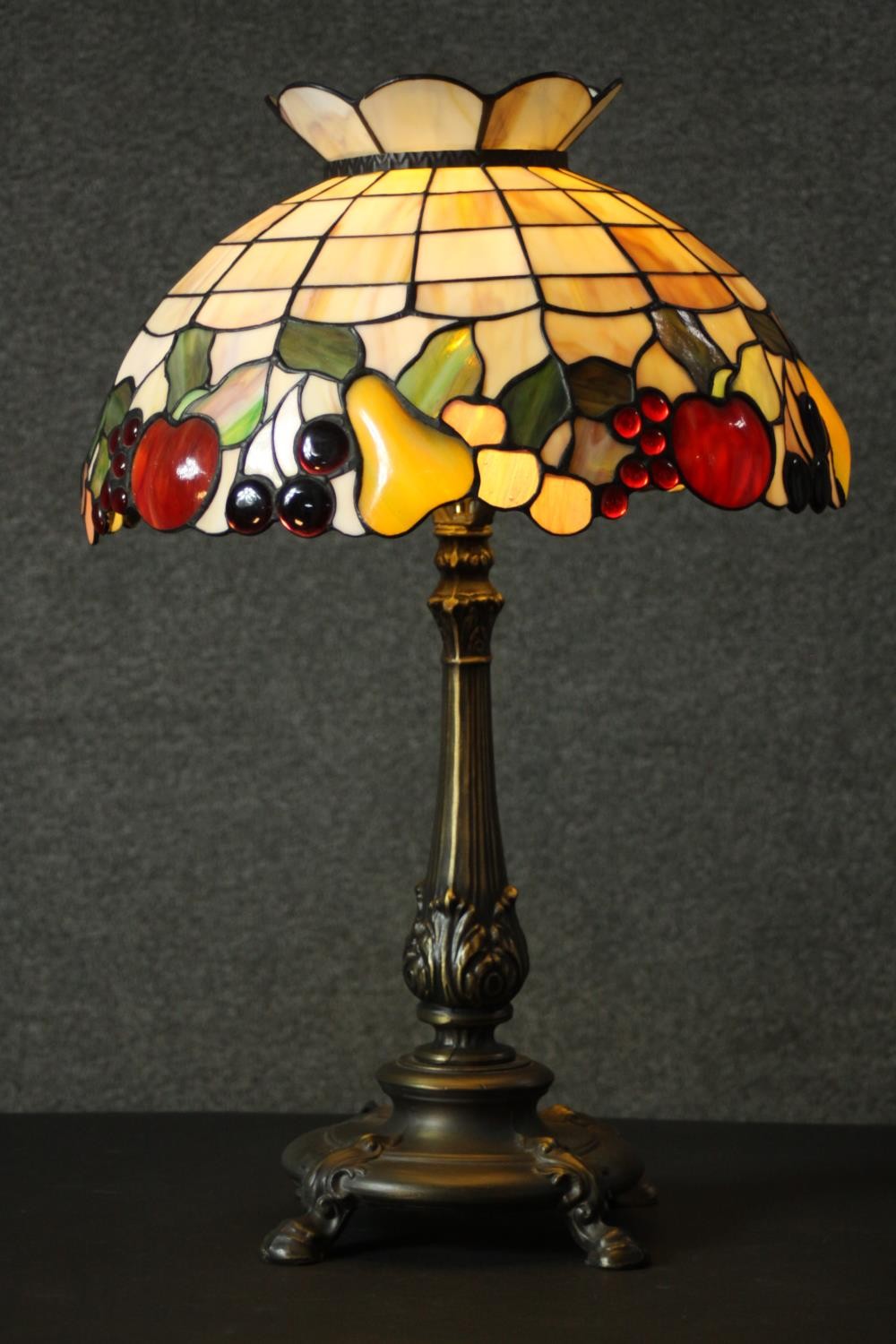 A Tiffany style table lamp, with a stained glass shade depicting fruit, the bronzed brass base - Image 6 of 10