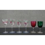 Four Orrefors hand painted glasses along with a green and cranberry glass wine glass. H.16 Diam.