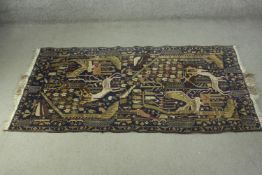 A hand made blue ground Zekhani Belouch rug with animal motifs across the midnight ground within