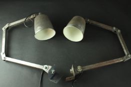 Two mid 20th century industrial steel anglepoise desk lamps, fitted to attach to a desk or work