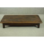 An elm low coffee table, of rectangular form with canted corners and a moulded edge, on square