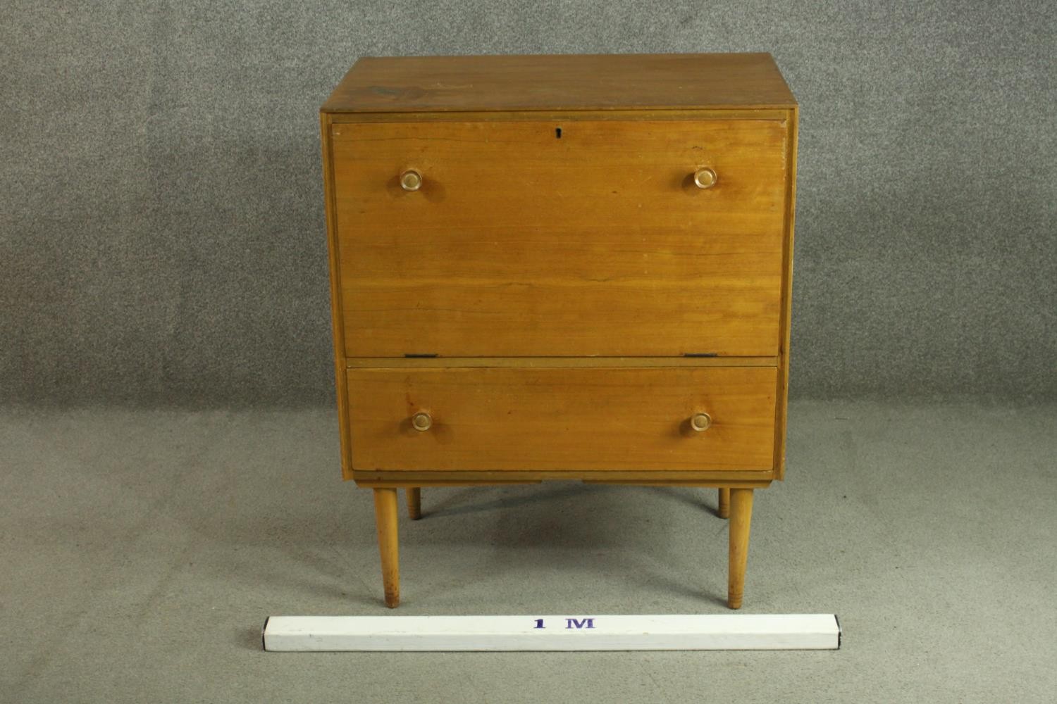 A circa 1950s teak cabinet, with a fall front enclosing a pull-out section, over a single drawer, on - Image 2 of 7