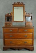 A late Victorian walnut dressing chest, with a central bevelled swing frame mirror, flanked by two