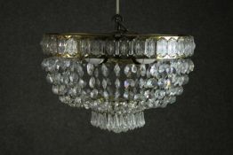 An Art Deco basket form chandelier, with a brass frame, hung with faceted lustres. H.28 Dia.40cm.