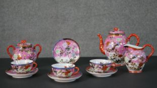 A Japanese hand painted porcelain part four person tea set. Each piece decorated with birds and