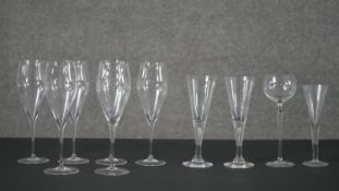 A collection of glasses, including a set of six champagne flutes, and four other assorted glasses.