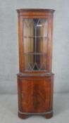 A Reprodux Bevan Funnell Ltd George III style mahogany corner cabinet, with a dentil cornice over an