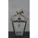A 20th century George III style cast metal hall lantern, with a scrolling top over four tapering