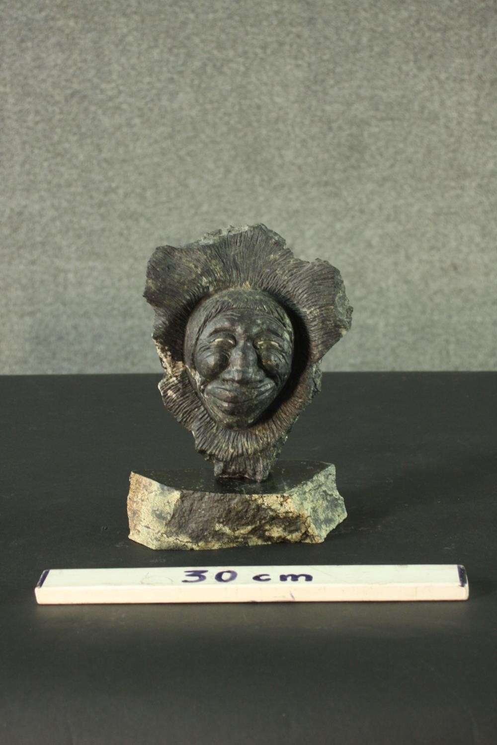 Joseph Suqslaq, Inuit, 1958- a carved green hardstone sculpture of a head of a man on a slab base, - Image 10 of 10
