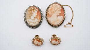 Two carved shell cameo brooches along with a pair of silver gilt screw back earrings with carved