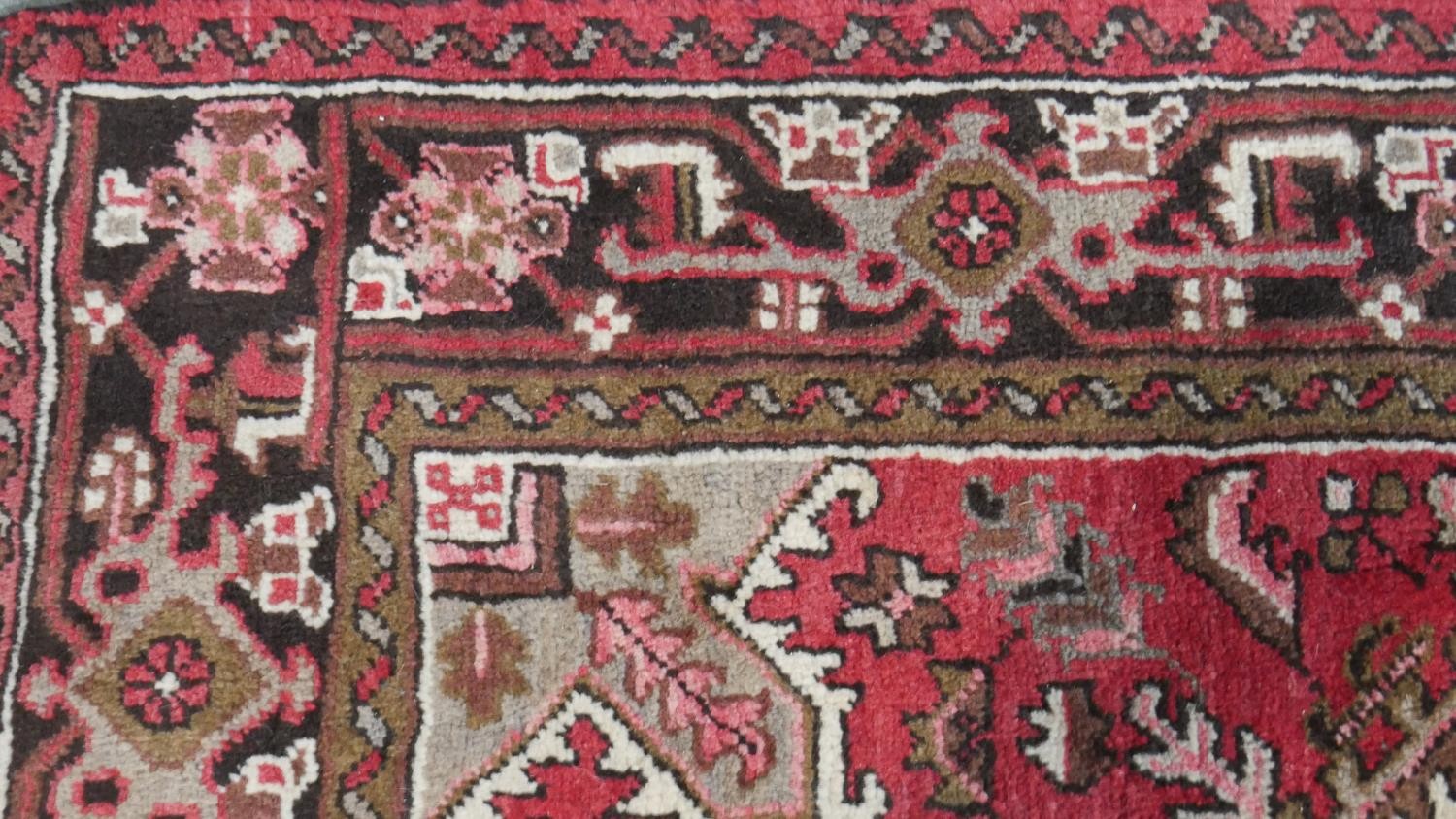 A hand made Persian Heriz carpet with central medallion on a madder field. L.201 W.158cm - Image 6 of 8
