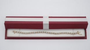 A boxed 9ct yellow and white gold interlocking heart link diamond set bracelet, set with 0.50 carats