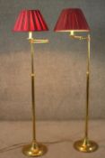 A pair of vintage brass height adjustable standard lamps with extending arms and circular base. H.