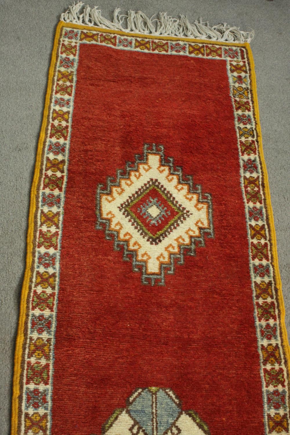 A Moroccan runner with hooked diamond medallions on a terracotta ground contained by multiple - Image 3 of 6