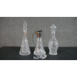 Two cut crystal decanters and a silver plate and crystal claret jug with an extra stopper. H.38cm (