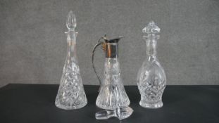 Two cut crystal decanters and a silver plate and crystal claret jug with an extra stopper. H.38cm (