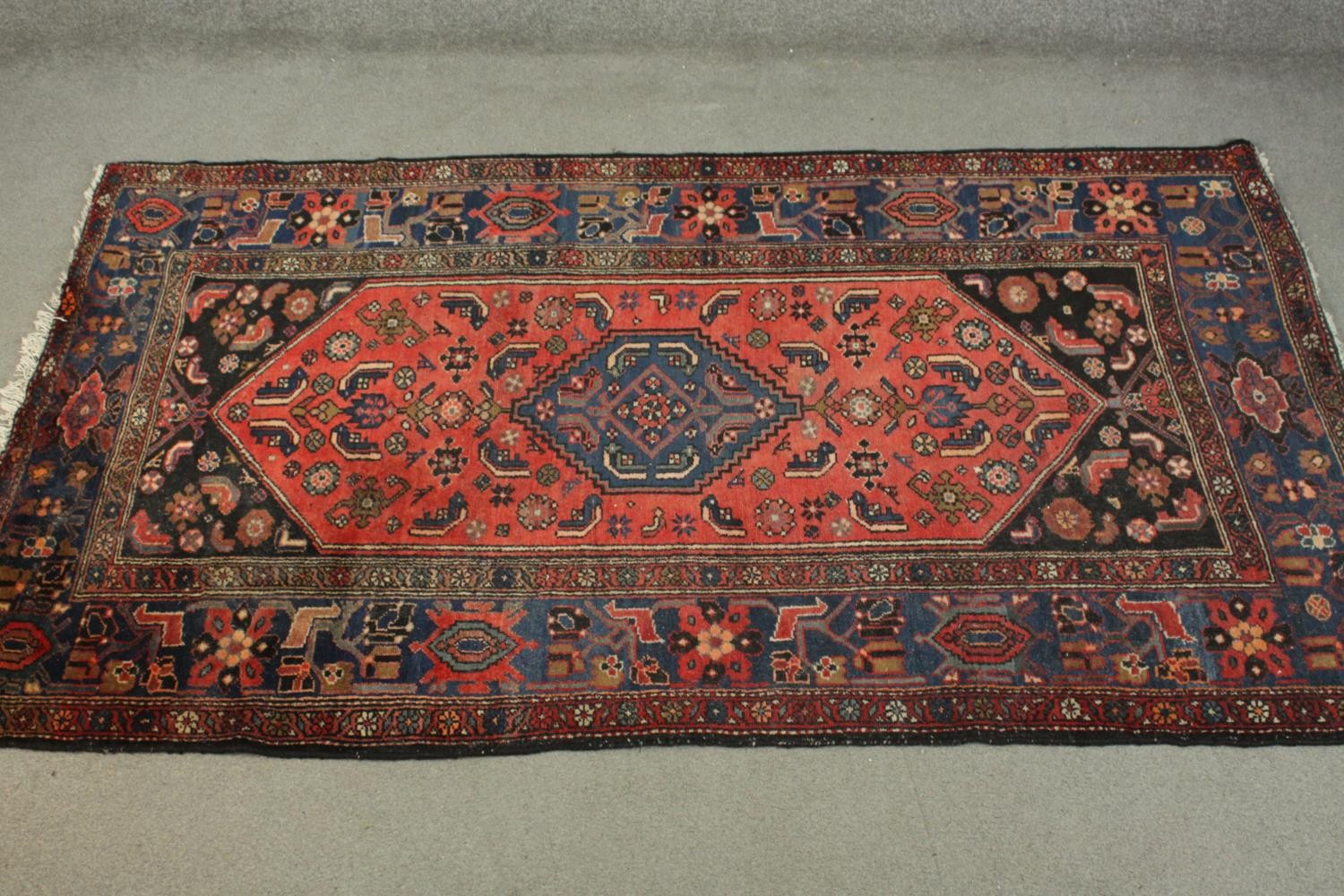 A hand made red ground Persian Hamadan carpet. L.210 W.129cm.