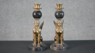 A pair of Egyptian revival black marble and brass winged sphinx candlesticks. H.28 W.11cm
