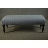 A Victorian style long stool, with an overstuffed seat upholstered in striped light blue fabric,
