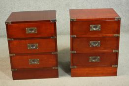A pair of campaign style yew wood bedside chests with three drawers and recessed handles, on a