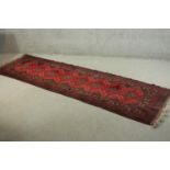 A hand made red ground Afghan runner. L.290 W.87cm.