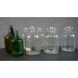 A collection of eight glass demijohns, one brown and one green glass. H.38cm (largest)