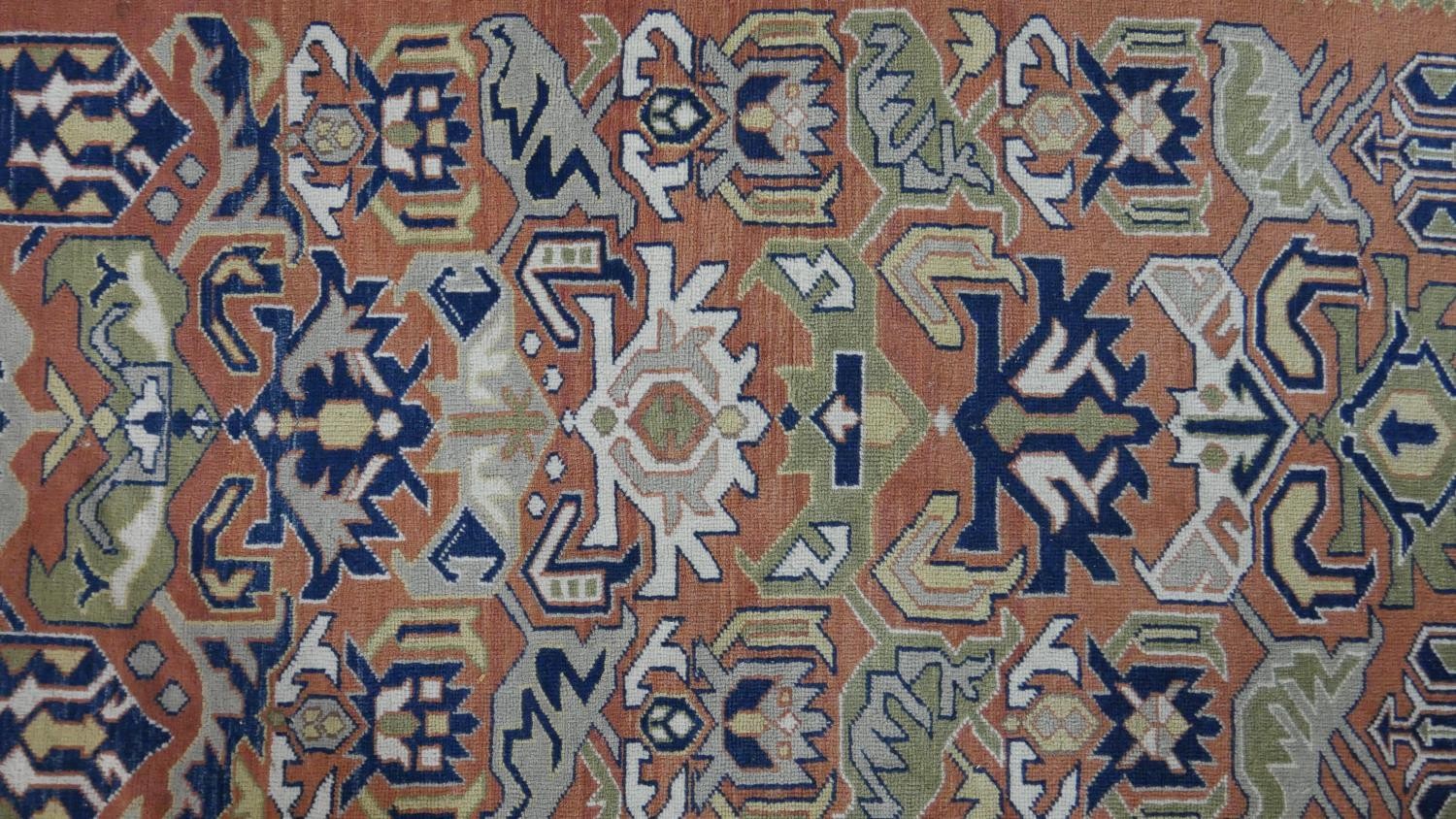 A handmade Russian Shirvan carpet with repeating stylised motifs on a pale terracotta ground - Image 3 of 7