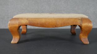 A satinwood footstool, with an embroidered seat, on cabriole legs. H.12 W.35 D.26cm