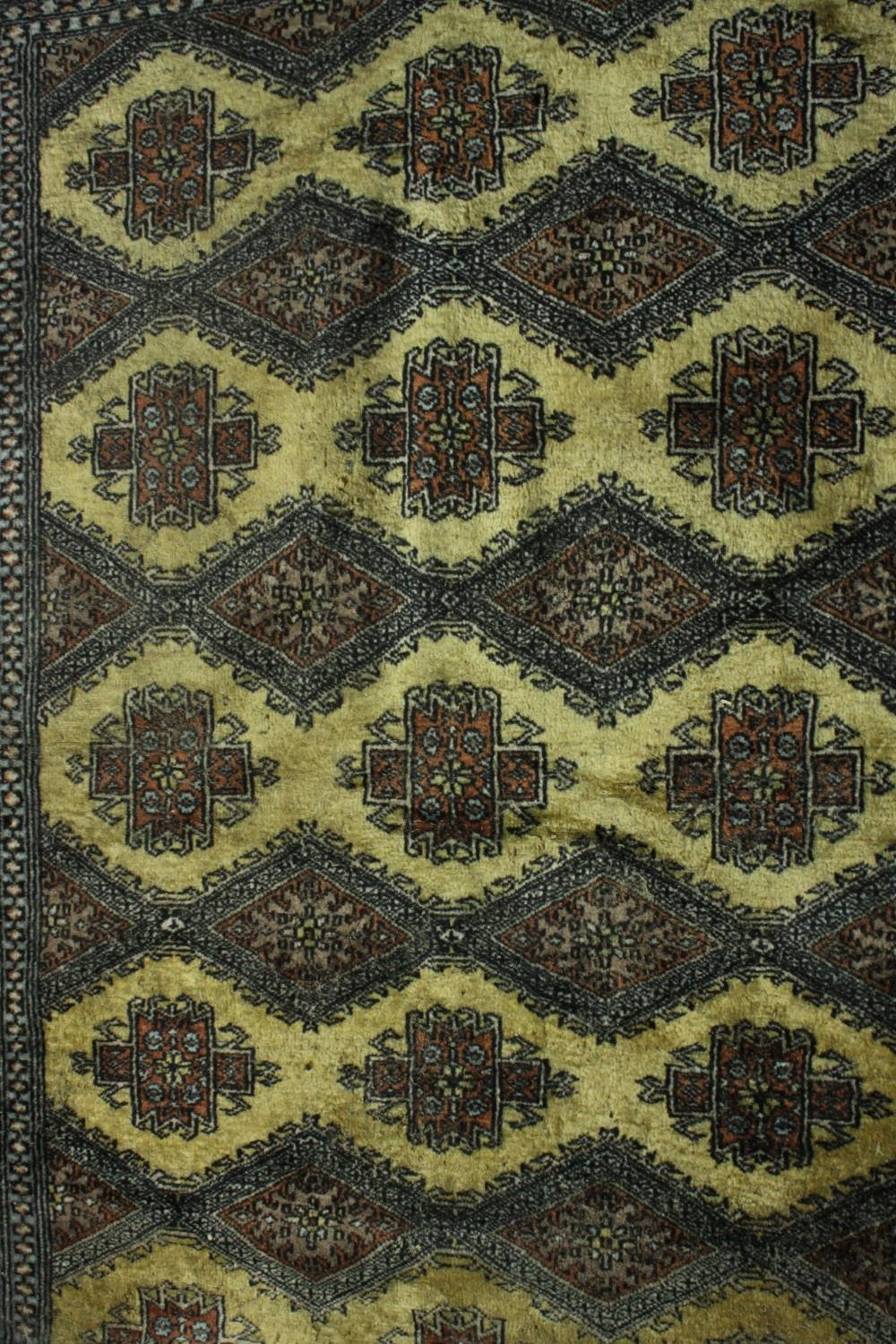 A Pakistan Bokhara rug with repeating stylised foliate motifs on a biscuit ground within multiple - Image 3 of 5