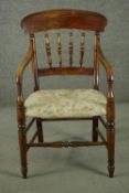 A rustic stained beech bar back open armchair, with turned spindles over a tapestry style seat, on