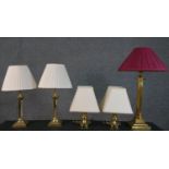 A collection of five brass table lamps, one of Corinthian column form, a pair of chamber sticks, and