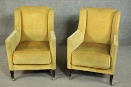 A pair of circa 1900 wing back armchairs, upholstered in yellow velour, on tapering square section
