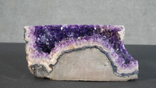 A large section of an amethyst geode. H.11 W.24 D.17cm