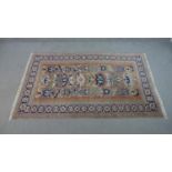 A handmade Russian Shirvan carpet with repeating stylised motifs on a pale terracotta ground