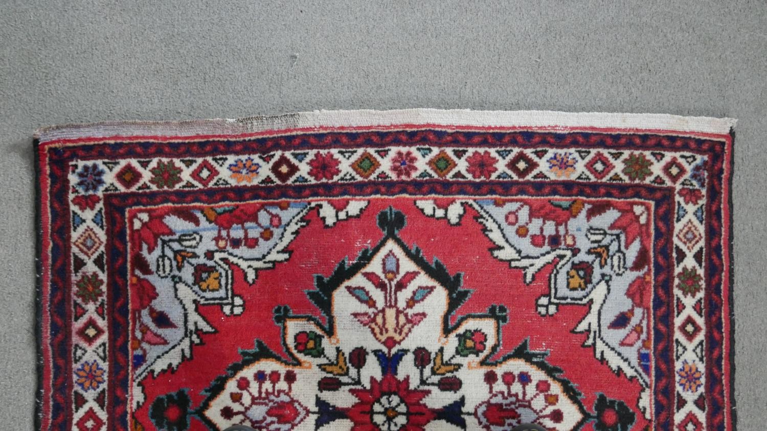 A handmade Persian Hamadan rug with repeating floral motifs across the madder ground within - Image 5 of 7