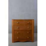 A late 20th century John Lewis chest of four long drawers with knob handles, over a shaped apron,