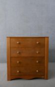 A late 20th century John Lewis chest of four long drawers with knob handles, over a shaped apron,