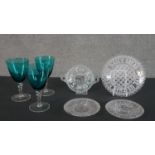 A collection of glass, including three turquoise wine glasses with clear twist stems and some