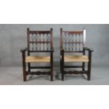 A pair of rustic spindle back open armchairs, with open arms and rush seats, on square section