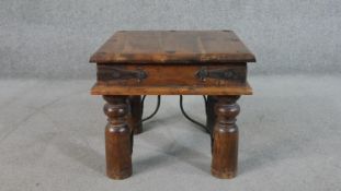A small Indian sheesham wood coffee table, the square top with studded details, over iron banding,