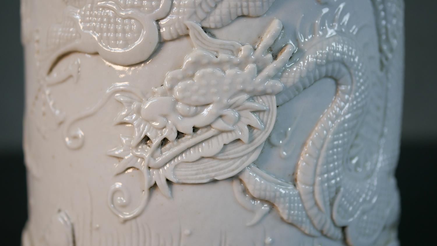 A Chinese blanc de chine relief porcelain dragon among the waves design brush pot. Impressed - Image 2 of 9