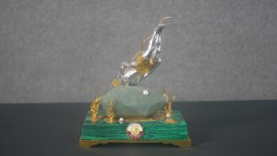 A bespoke Royal Insignia white and gilt metal figure of a pearl diver with gold plated shorts,