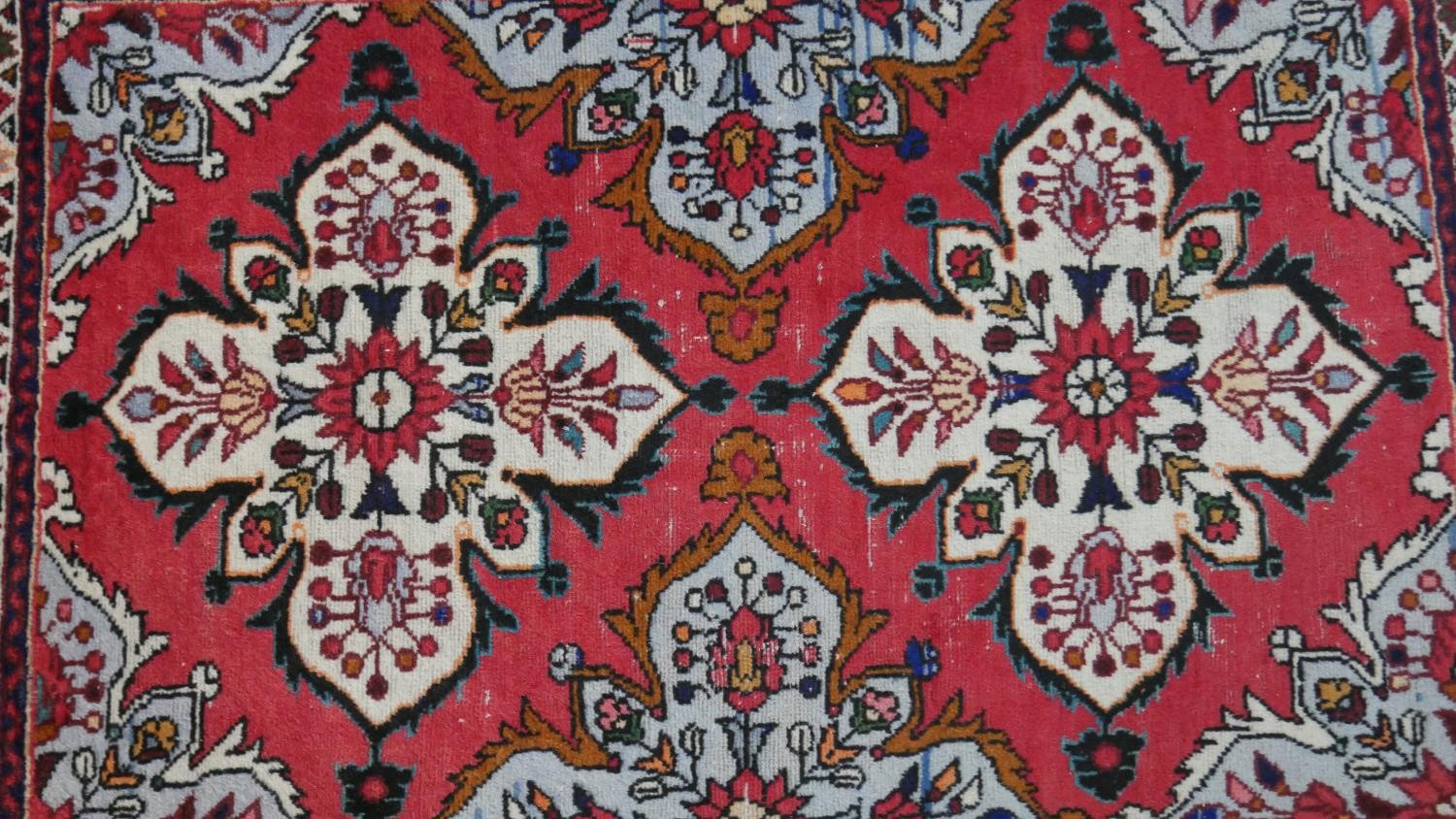 A handmade Persian Hamadan rug with repeating floral motifs across the madder ground within - Image 3 of 7