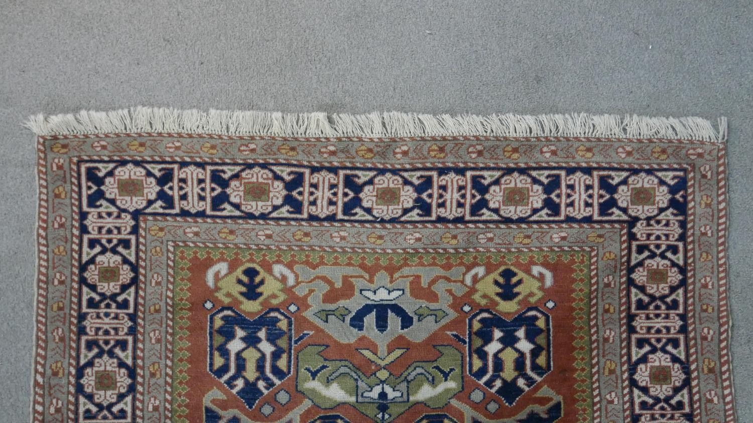 A handmade Russian Shirvan carpet with repeating stylised motifs on a pale terracotta ground - Image 5 of 7